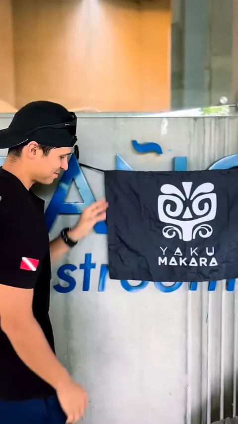 Un makara fija en la pared de concreto la bandera negra con la máscara del club